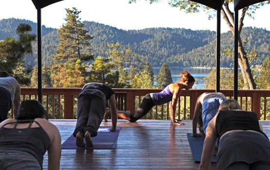 A yoga instructor leading a class on the Zen Deck with mountains in the background