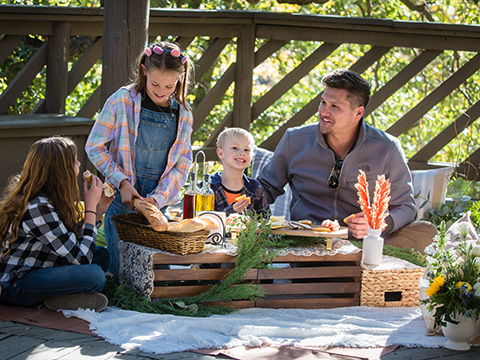 a family enjoys a spring picnic under the treehouse at lake arrowhead lodge