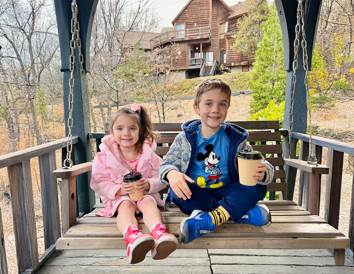 kids enjoying a bench swing at the lodge
